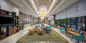 a lobby with couches and chairs and a television at Doubletree By Hilton Antalya City Centre in Antalya