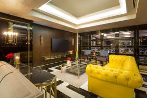 a living room with a yellow couch and a tv at DoubleTree By Hilton Izmir Airport in Izmir