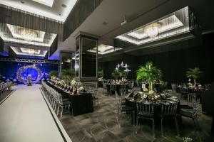 a banquet hall with tables and chairs and chandeliers at DoubleTree By Hilton Izmir Airport in İzmir