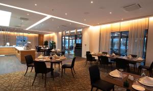 DoubleTree by Hilton Ankara Incek في أنقرة: مطعم بطاولات وكراسي ومطبخ