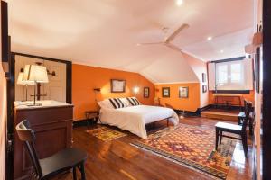 Schlafzimmer mit orangefarbenen Wänden, einem Bett und einem Fenster in der Unterkunft Casa Grande - Minho's Guest in Braga