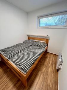 łóżko w pokoju z oknem w obiekcie U srubu w mieście Moravany