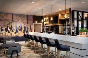a bar in a restaurant with a row of stools at Hampton By Hilton Bristol Airport in Redhill