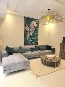 uma sala de estar com um sofá e uma mesa em Riad Isahiac avec piscine en exclusivité em Marrakech