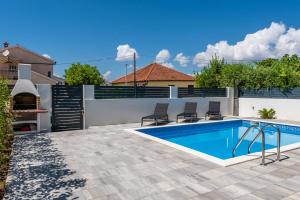 a swimming pool in a backyard with a fence at Villa Angelo Vrsi in Vrsi
