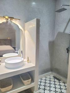 W łazience znajduje się umywalka i lustro. w obiekcie Riad Isahiac avec piscine en exclusivité w Marakeszu