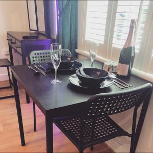 a black table with two glasses and a bottle of wine at Beverley Snug in Beverley