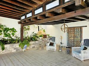 Nazaret的住宿－Villa Nazoly，庭院设有白色椅子和木制天花板。