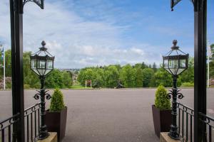 two lights on a fence with a basketball court at DoubleTree by Hilton Dunblane Hydro Hotel in Dunblane