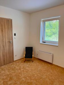 pusty pokój z krzesłem i oknem w obiekcie U srubu w mieście Moravany
