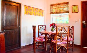 a dining room with a table and chairs and a door at Sanka's Casita on Playa La Madera near Centro in Zihuatanejo