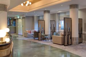 a lobby with couches and chairs and columns at Hilton Nottingham Hotel in Nottingham