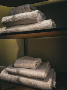 einen Stapel Handtücher auf einem Regal im Bad in der Unterkunft B&B La Rosa 