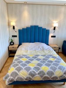 - un grand lit avec une tête de lit bleue dans une chambre dans l'établissement Splendide Studio avec balcon - Trouville centre, à Trouville-sur-Mer