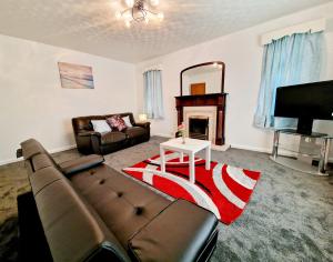 un soggiorno con divano e camino di Chimes-Company & Family Stay, 2 Bedroom House + Free parking a Tamworth