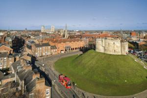 vistas a una ciudad con un castillo y un autobús rojo en Hilton York en York