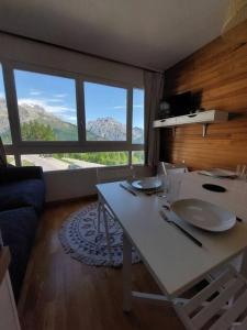 uma sala de estar com uma mesa branca e uma grande janela em Joli studio 4 couchages aux pieds des pistes em Puy-Saint-Vincent