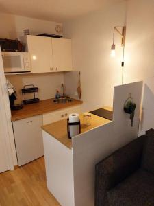 uma cozinha com armários brancos e uma bancada em Joli studio 4 couchages aux pieds des pistes em Puy-Saint-Vincent