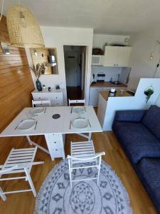 uma sala de estar com uma mesa e cadeiras e um sofá em Joli studio 4 couchages aux pieds des pistes em Puy-Saint-Vincent