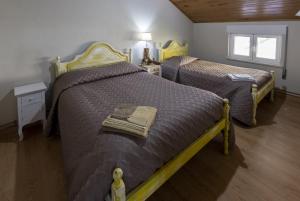 een slaapkamer met twee bedden en een raam bij Casas do Patrao II in Sabugueiro