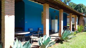 une maison bleue avec une table et des chaises dans l'établissement SITIO DO BIRA, à São Joaquim de Bicas