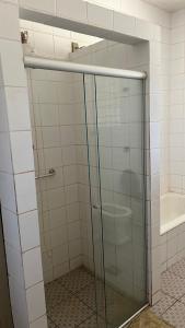 La salle de bains est pourvue d'un lavabo et d'une porte de douche en verre. dans l'établissement SITIO DO BIRA, à São Joaquim de Bicas