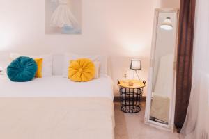 una camera da letto con un letto bianco con due cuscini e uno specchio di PERFECT STAY 4 a Cluj-Napoca