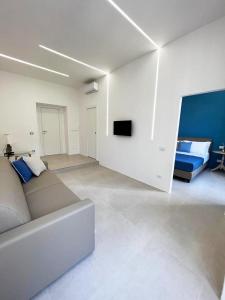 sala de estar blanca con sofá y TV en BiRooms en Nápoles