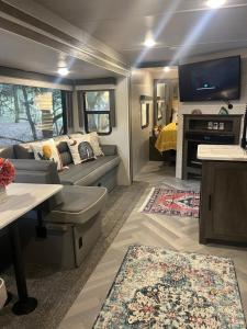 a living room with a couch and a tv at Your Personal 'Glamp' Site! AC - BBQ - Fast WiFi in DeLand