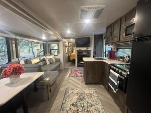 a kitchen and living room of an rv at Your Personal 'Glamp' Site! AC - BBQ - Fast WiFi in DeLand