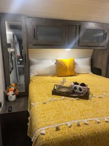 a bedroom with a yellow bed with a camera on it at Your Personal 'Glamp' Site! AC - BBQ - Fast WiFi in DeLand