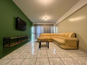 a living room with a couch and a flat screen tv at Pousada VSC in São Francisco do Sul