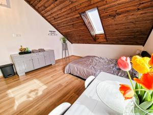 ein Schlafzimmer mit einem Bett und einem Tisch mit Blumen in der Unterkunft GraVelo - Apartament Jacuzzi in Bartkowa-Posadowa