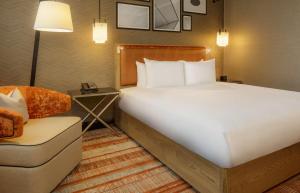 Pokój hotelowy z dużym łóżkiem i krzesłem w obiekcie Hilton London Tower Bridge w Londynie
