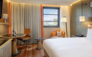 um quarto de hotel com uma cama, uma mesa e uma janela em Hilton London Tower Bridge em Londres