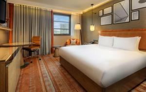 a hotel room with a large bed and a desk at Hilton London Tower Bridge in London