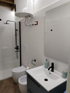 een badkamer met een witte wastafel en een toilet bij Mondello Apartment in Mondello