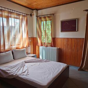Un dormitorio con una cama grande y una ventana en Anilio Rooms, en Anilio - Metsovo