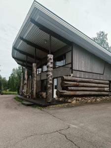 een gebouw met een gambrel dak met houtblokken erop bij Joensuu Villa Cuisine in Joensuu