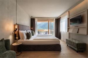 a bedroom with a large bed and a window at Hotel Valentinerhof in Siusi