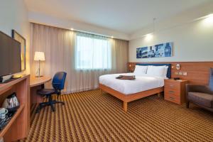 a hotel room with a bed and a television at Hampton by Hilton Luton Airport in Luton
