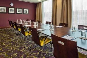 ein großer Konferenzraum mit einem langen Tisch und Stühlen in der Unterkunft Hampton by Hilton Luton Airport in Luton