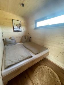 a bed in a wooden room with a window at Ferienresort Edersee GmbH in Hemfurth-Edersee