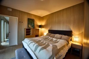 a bedroom with a large bed and wooden walls at NEW! Lofoten Luxury Home near Henningsvaer in Lyngværet