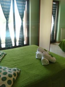a green bed with two towels on top of it at Villino Ulivo in Le Casette