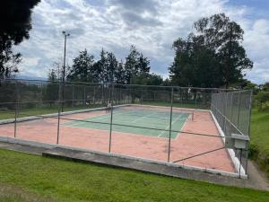 a tennis court with a net on a field at Quito Airport Suites Hotel in Tababela