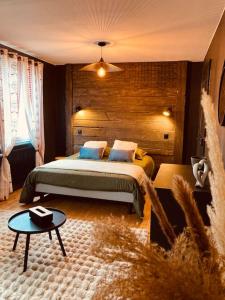 a bedroom with a large bed and a table at Maison Les Planches in Gérardmer