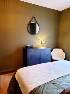 a bedroom with a bed and a mirror and a chair at Maison Les Planches in Gérardmer