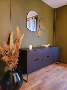 a bathroom with a dresser and a mirror at Maison Les Planches in Gérardmer