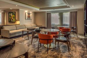 a hotel room with tables and chairs and a couch at Hilton London Watford in Watford